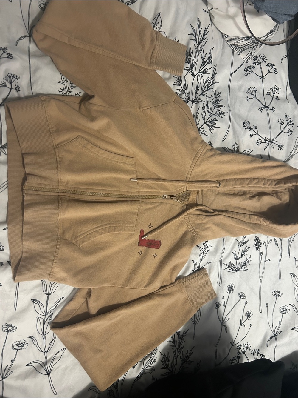 Zumiez tan hooded zip-up with red embroidered boot motif